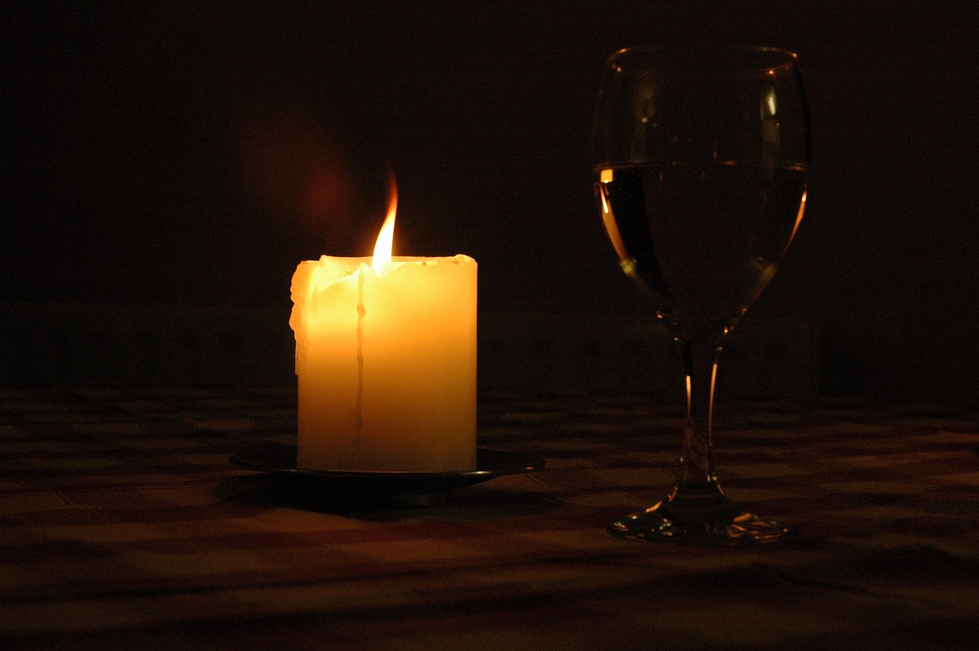 A single candle burning in a dark room