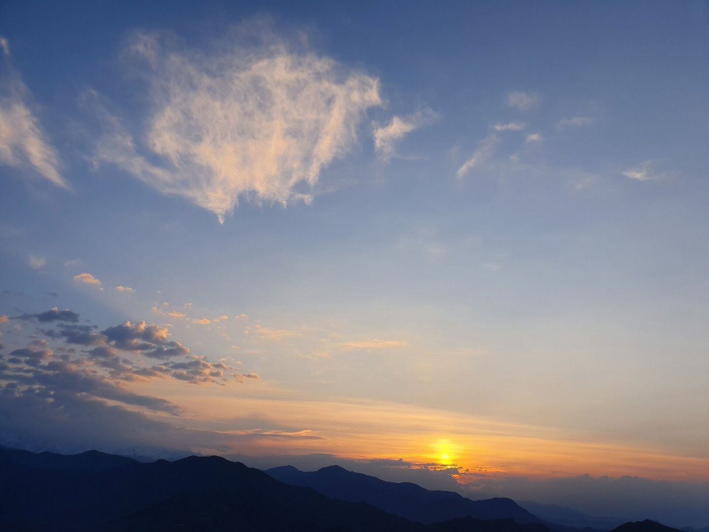The first light of dawn breaking over a mountain ridge
